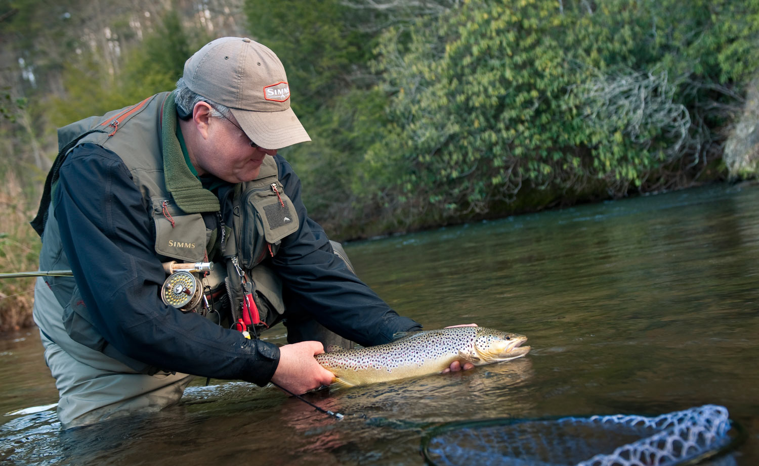 Dan Flynn relaxes with a nice brown trout. photo by Louis Cahill